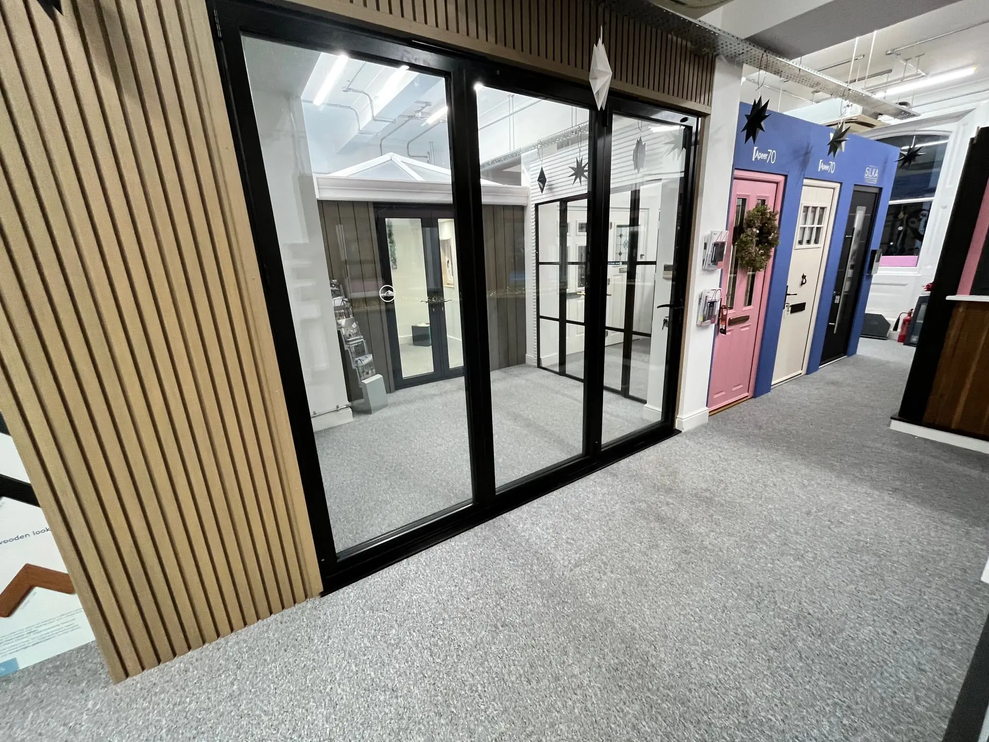 Black aluminium sliding-door display beside the showroom's entrance-door displays