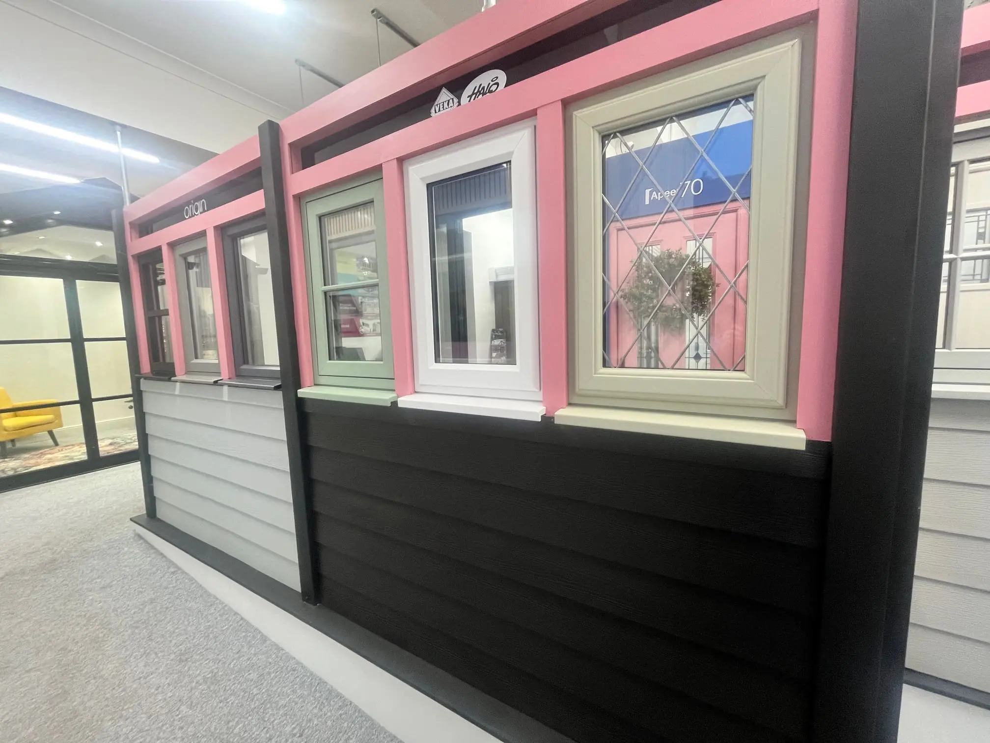 Window displays with different frame styles and decorative glass inside the Spectrum Glazing showroom