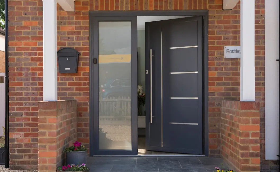 Dark Origin front door with a tall frosted sidelight in a red-brick entrance