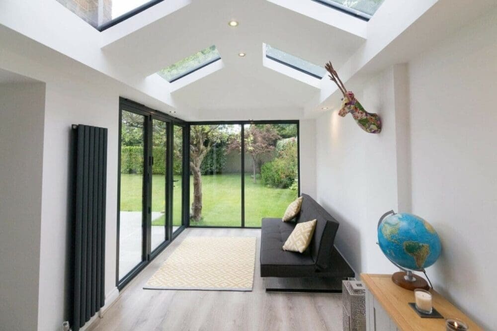 Livinroof interior with shaped roof glass, plastered ceiling and garden-facing doors