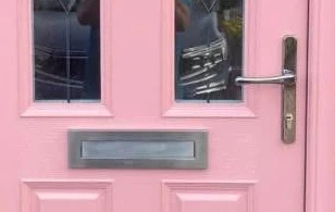 Close-up of the chrome handle and letterplate on this pink Apeer 70 door